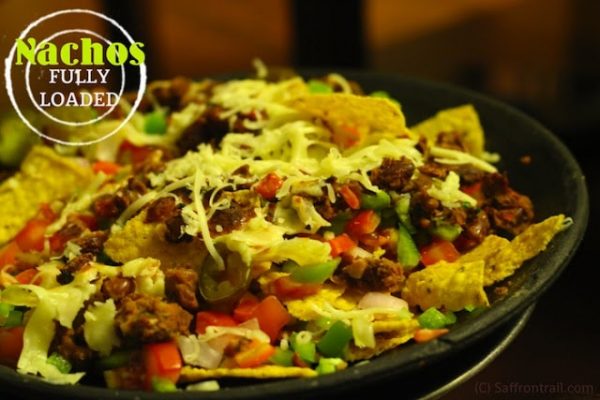 the-secret-to-making-fully-loaded-nachos-recipe.25319.jpg Loaded Nachos topped with refried beans & more